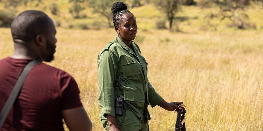 Een vrouw met een geweer op de savanne